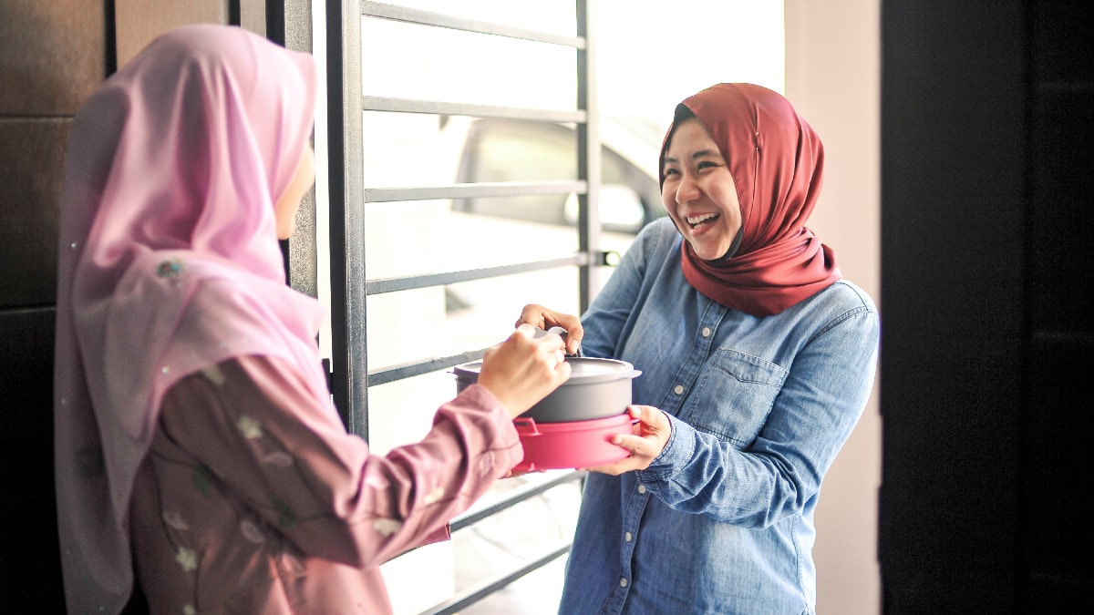 2 hijabi Muslim women sharing a kind gesture