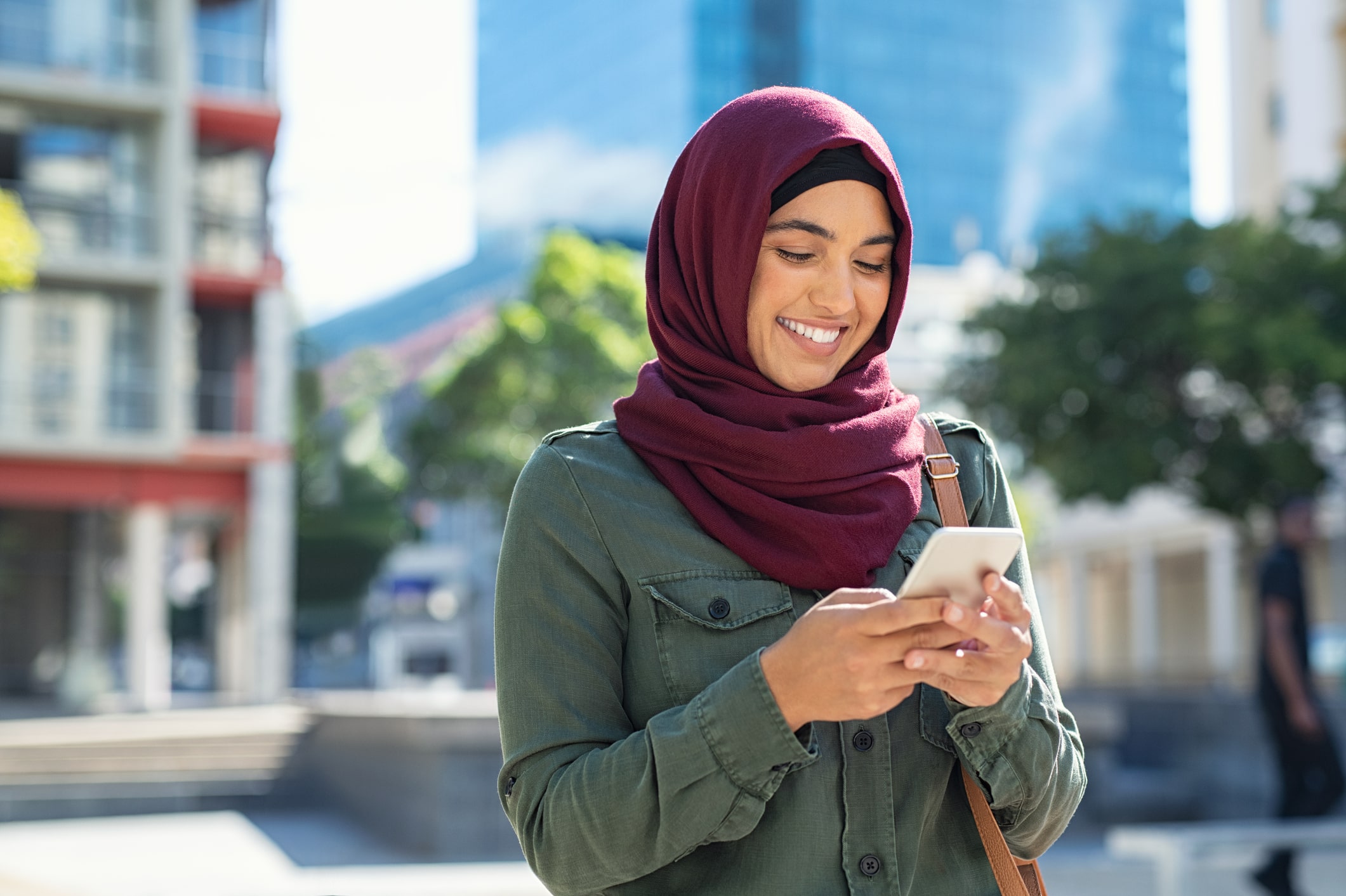 A young Muslim woman using her phone.
