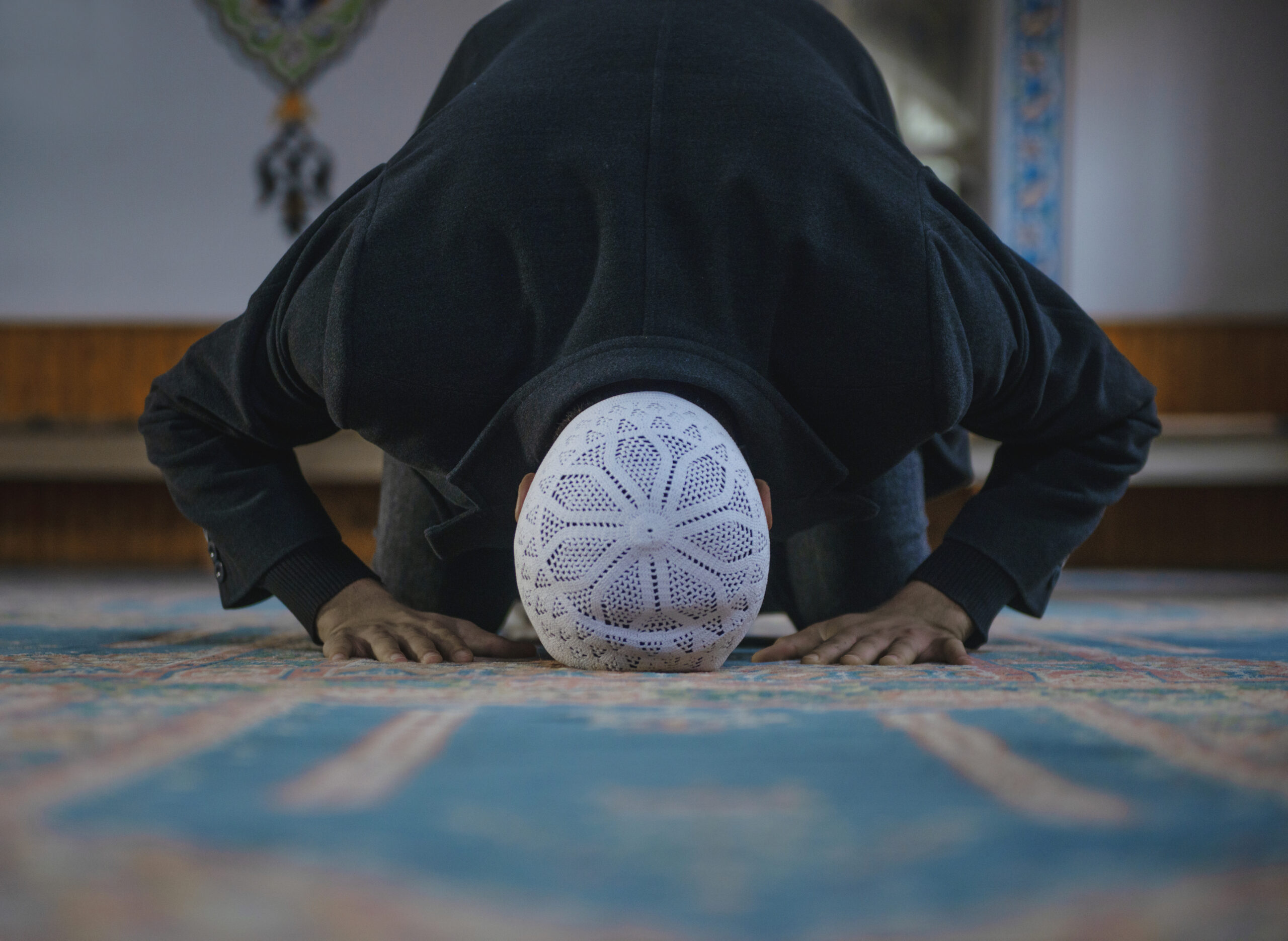Close-up shot of a Muslim young man worshiping in a mosque