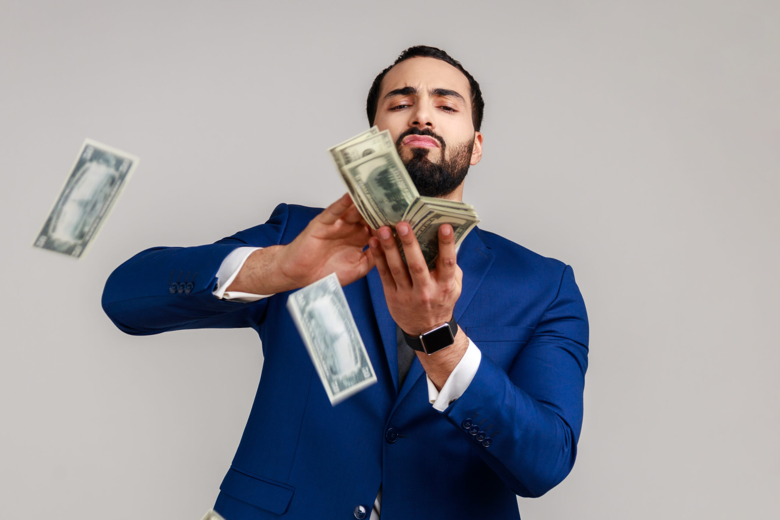 scattering money, wasting, careless bearded muslim man