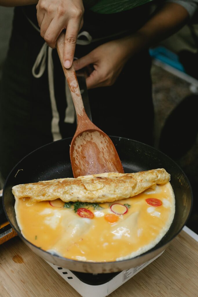 Cooking an omelette with a wooden spatula