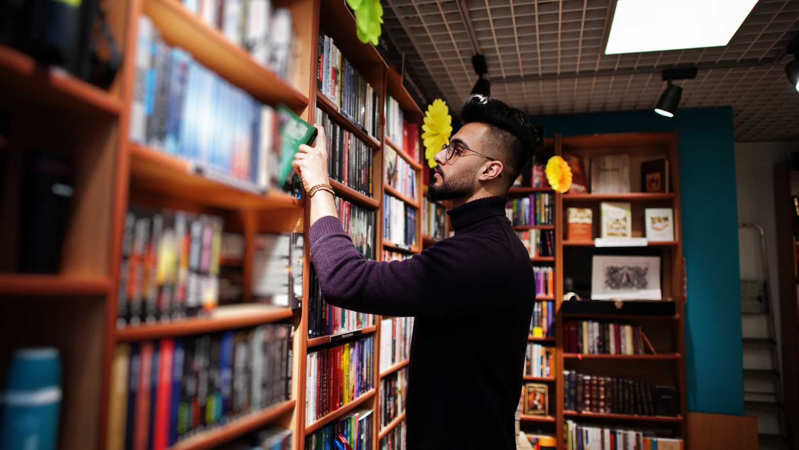 Man searching for books at a bookstore