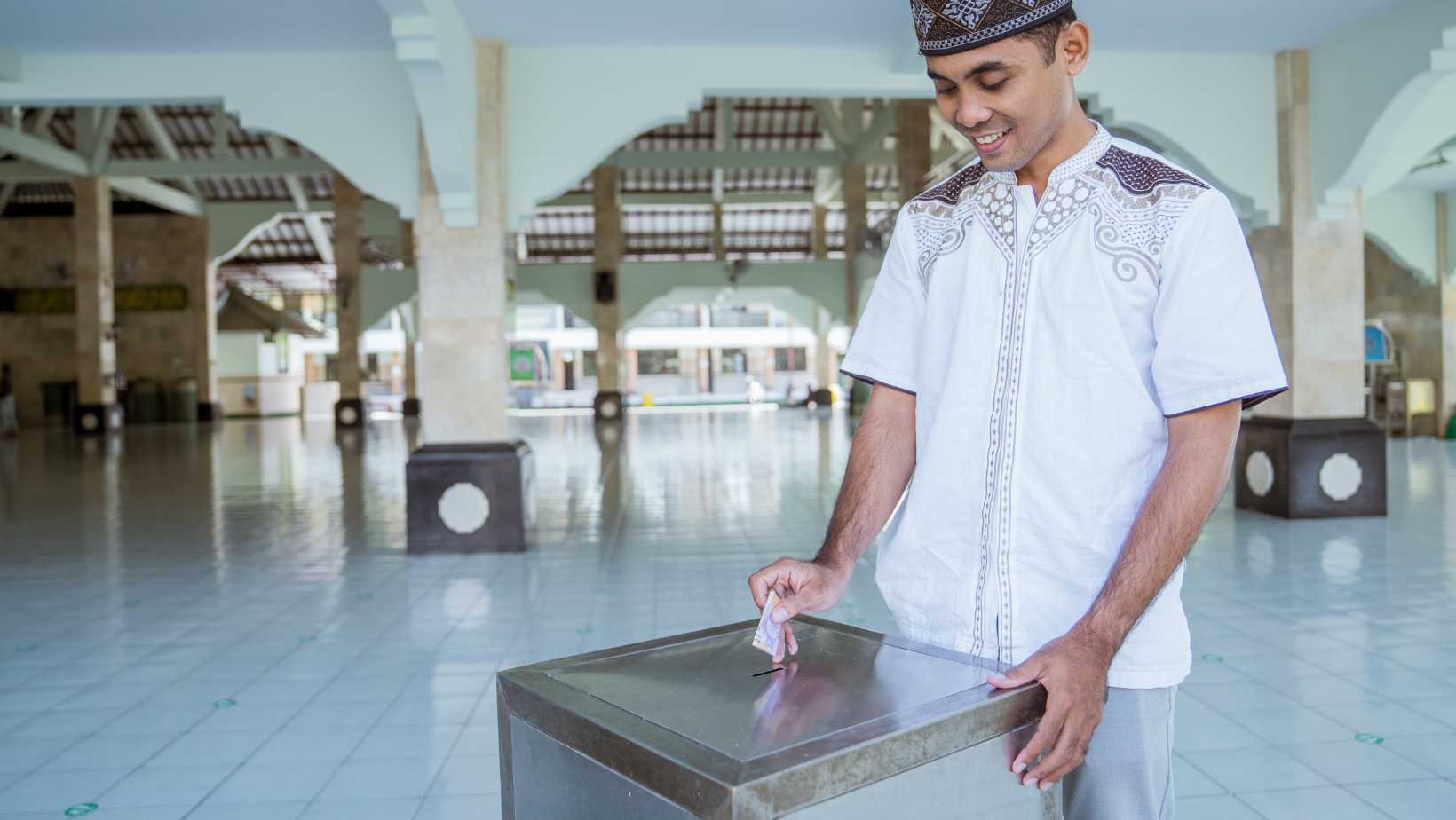 indonesian muslim man donating to charity at the mosque